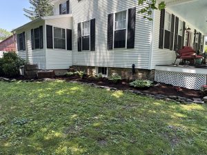 Fresh mulch and hosta landscape bed beside home by Justin's Lawn Service